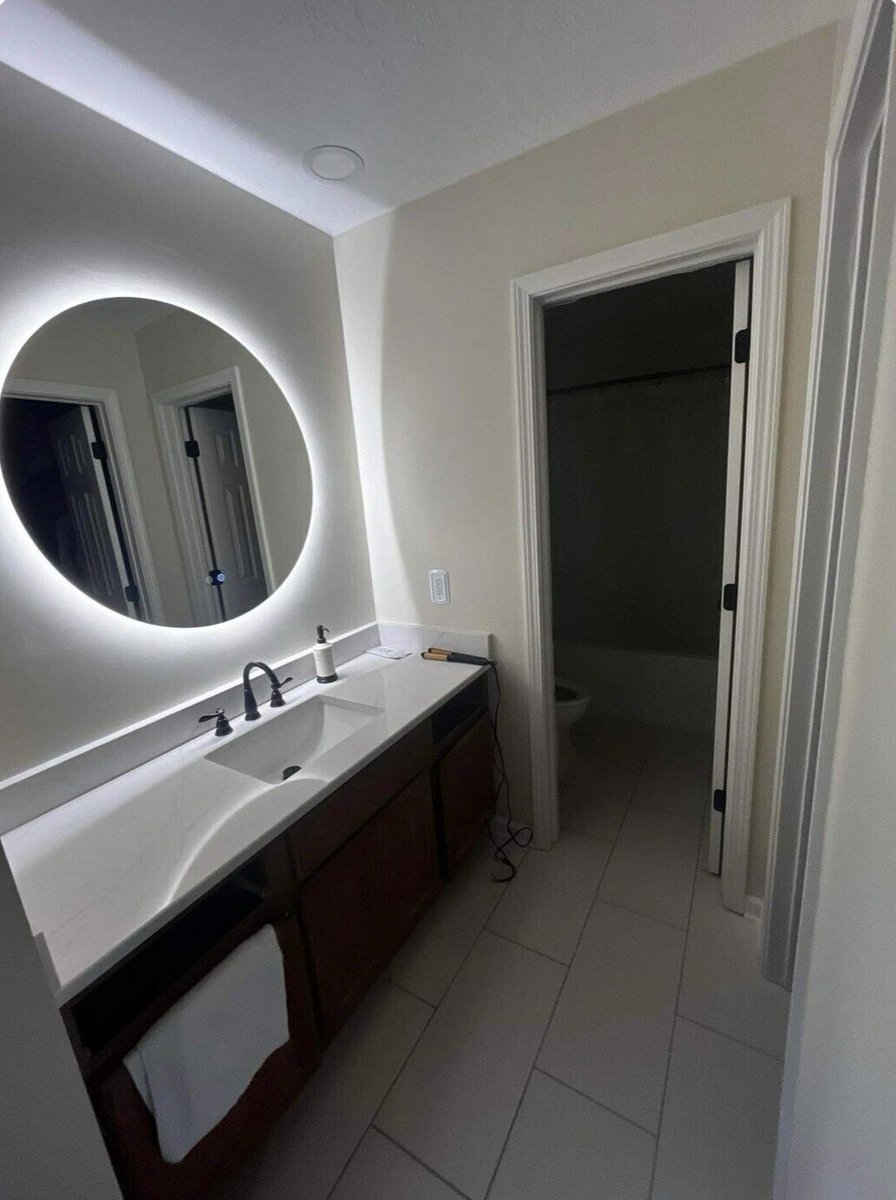 Double vanity bathroom remodel with LED mirror and modern fixtures by Wolfe Construction in Jackson, TN