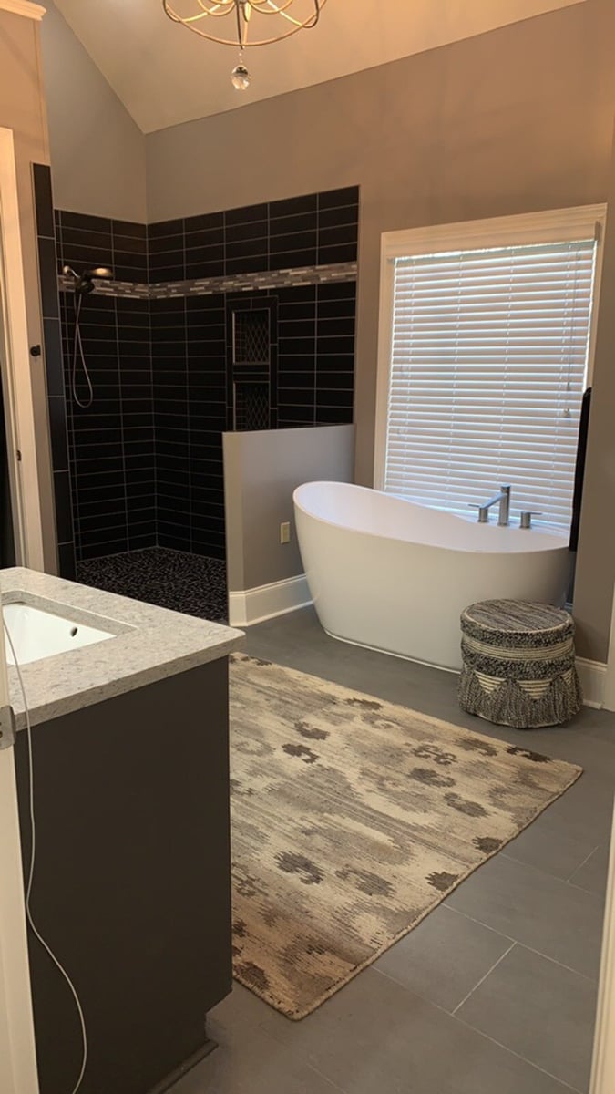 Elegant bathroom with a freestanding tub and dark tiled walk-in shower by Wolfe Construction in Jackson, TN