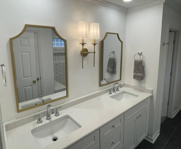Elegant double vanity bathroom with gold-framed mirrors by Wolfe Construction in Jackson, TN-1