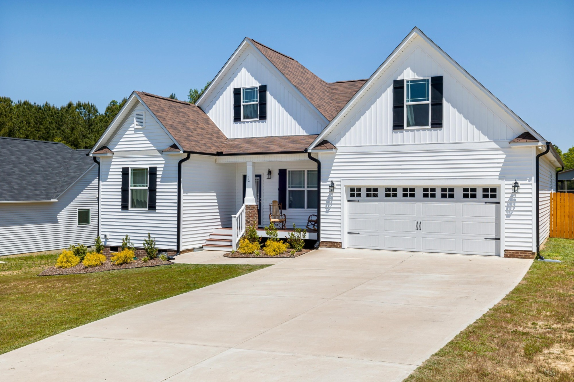 white custom farmhouse with black shutters and two car garage in jackson tn custom homes stock