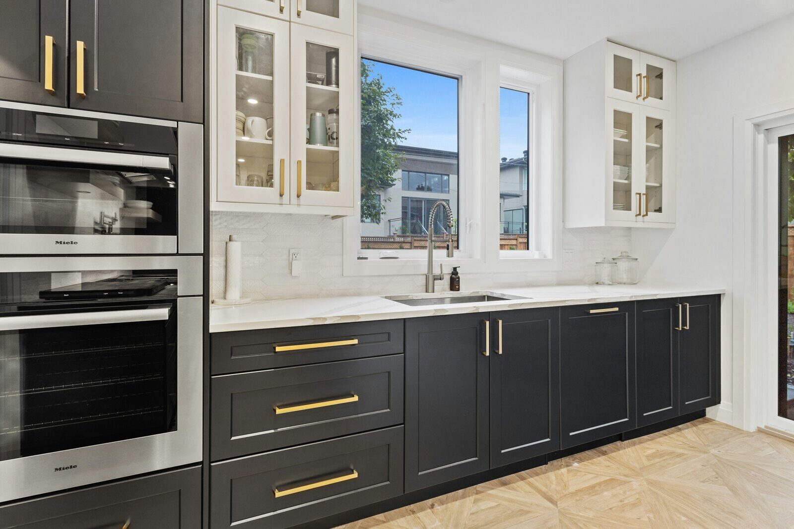 Kitchen with black lower cabinets, white uppers, gold hardware, and ample counter space - How Do You Know When It’s Time for a Kitchen Remodel- Wolfe Construction Co - West Tennessee - Home Builder & Remodeler