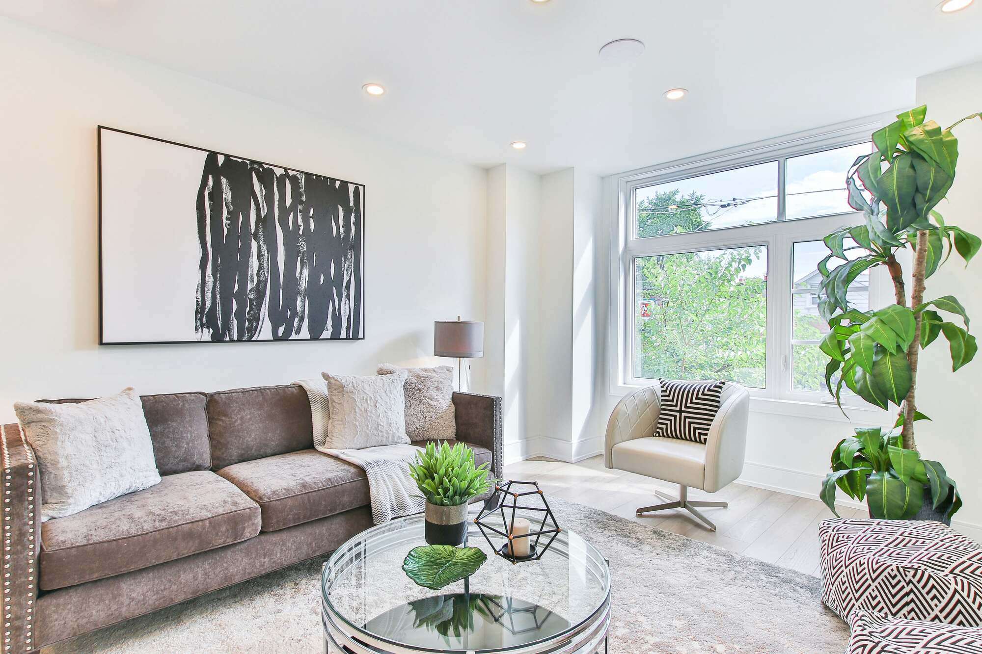 Living room remodel with a large window, modern furnishings, and neutral decor - The Home Remodeling Process & Timeline - Wolfe Construction Co - West Tennessee - Home Builder & Remodeler