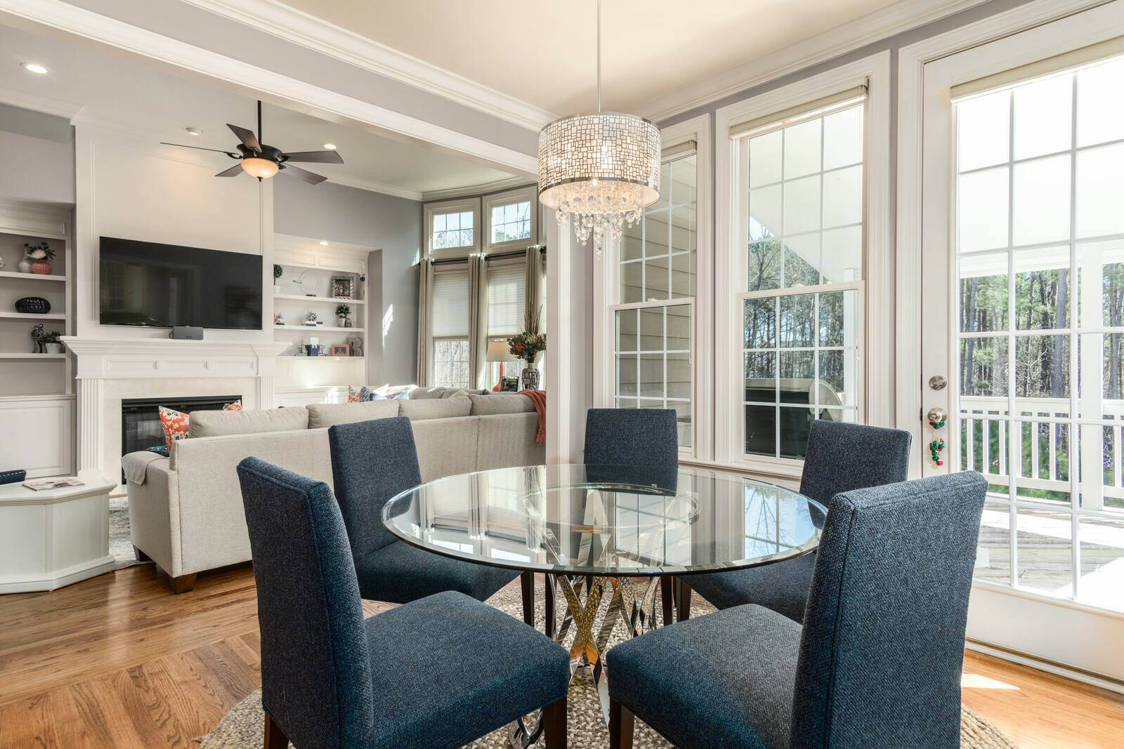 Home Additions - Elegant dining and living area with large windows, a glass table, and modern lighting by Wolfe Construction in Jackson, TN Home Additions - Elegant dining and living area with large windows, a glass table, and modern lighting by Wolfe Construction in Jackson, TN