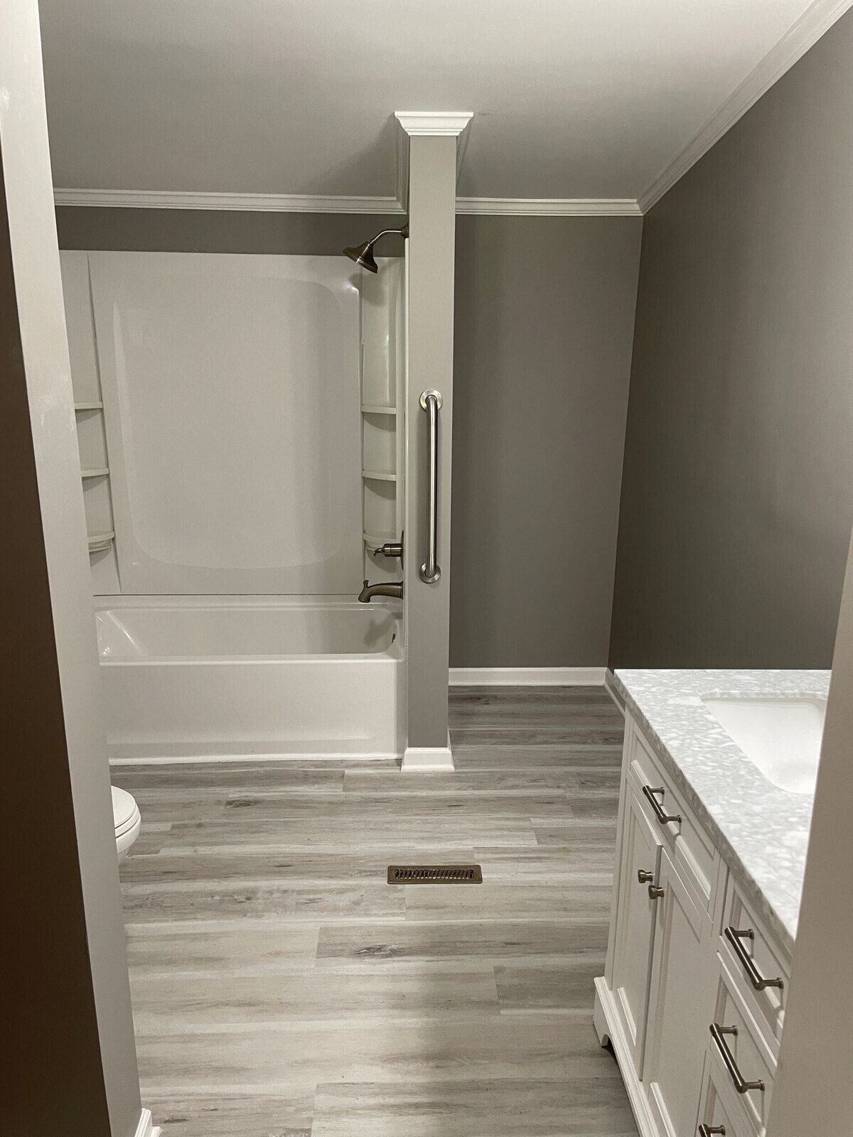 Bathroom remodel with white cabinetry and sleek chrome fixtures by Wolfe Construction in Jackson, TN