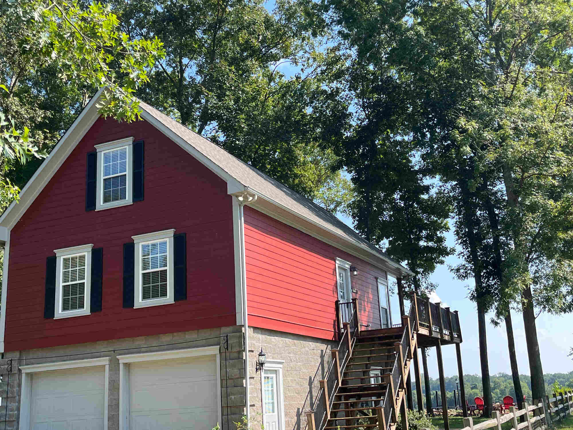 West Tennessee-Professional-Roofing-Services- Wolfe Construction Co.-Angled view of a remodeled garage with red siding, a deck, and new roofing by Wolfe Construction in Jackson, TN