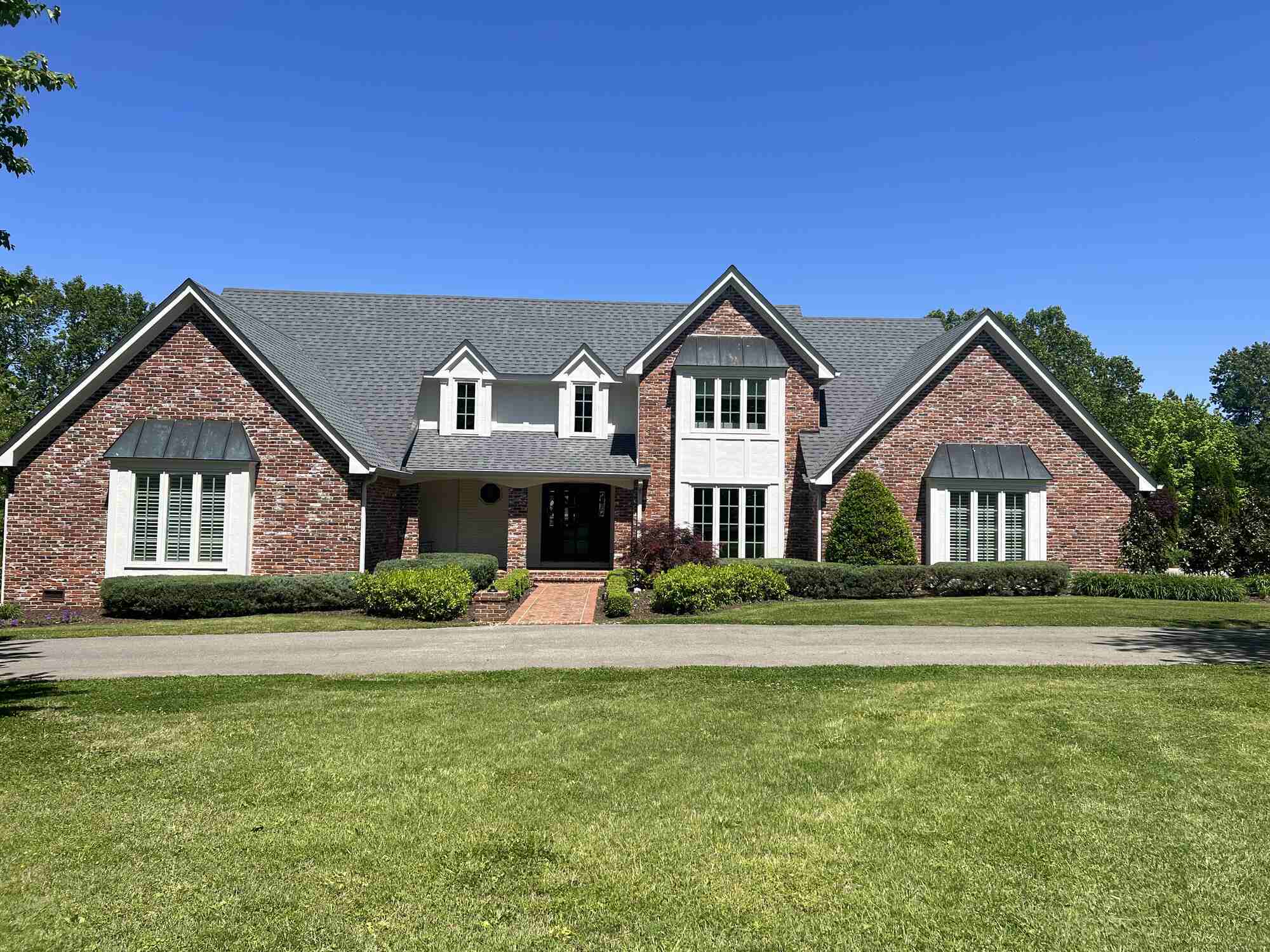 West Tennessee-Professional-Roofing-Services- Wolfe Construction Co.-Full view of a remodeled brick home with a new roof and landscaped front yard by Wolfe Construction in Jackson, TN